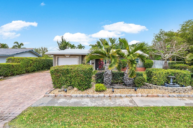 1707 NW 38th St, Oakland Park, FL 33309 - view of front of house featuring an attached garage, decorative driveway, fence, and stucco siding