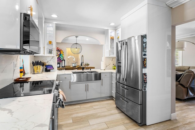 1707 NW 38th St, Oakland Park, FL 33309 - kitchen featuring stainless steel fridge with ice dispenser, electric range, a sink, arched walkways, and backsplash