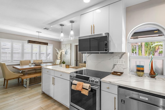 1707 NW 38th St, Oakland Park, FL 33309 - kitchen with a wealth of natural light, visible vents, white cabinets, and appliances with stainless steel finishes