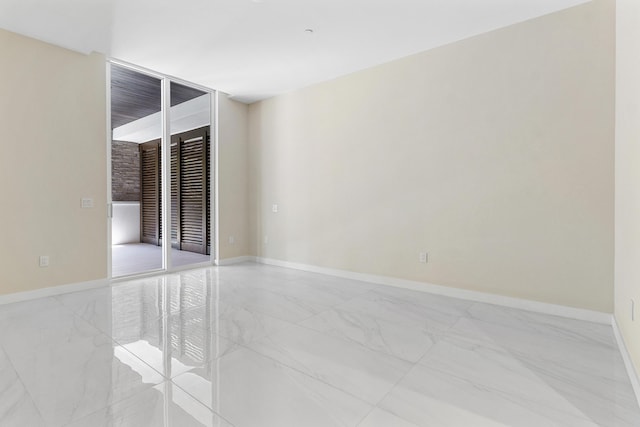 empty room with light marble finish flooring and baseboards
