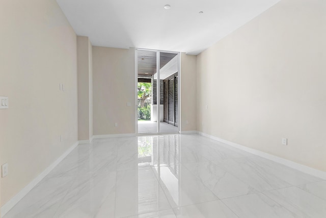 empty room with light marble finish floors and baseboards