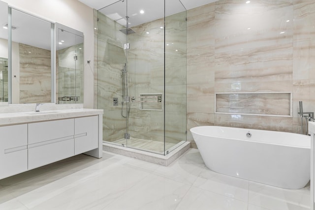 bathroom featuring a marble finish shower, vanity, a soaking tub, tile walls, and marble finish floors