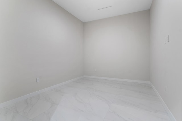 spare room with light marble finish flooring and baseboards