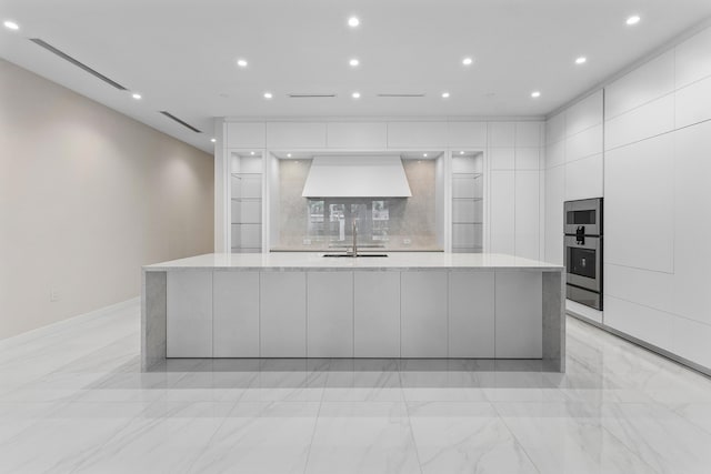 kitchen with modern cabinets, a sink, white cabinets, light marble finish flooring, and recessed lighting