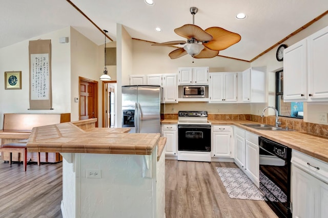 13298 82nd St N, West Palm Beach, FL 33412 - kitchen featuring appliances with stainless steel finishes, a sink, light wood-style floors, tile counters, and recessed lighting
