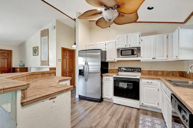 13298 82nd St N, West Palm Beach, FL 33412 - kitchen featuring stainless steel appliances, a sink, ceiling fan, light wood-style floors, and tile countertops