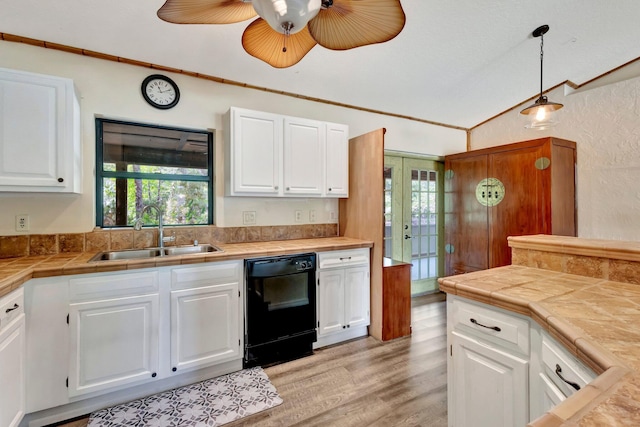 13298 82nd St N, West Palm Beach, FL 33412 - kitchen with black dishwasher, a sink, plenty of natural light, vaulted ceiling, and white cabinets