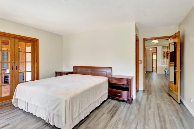 13298 82nd St N, West Palm Beach, FL 33412 - bedroom with light wood-style floors, french doors, and baseboards