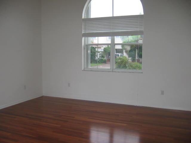 unfurnished room with a healthy amount of sunlight and wood finished floors