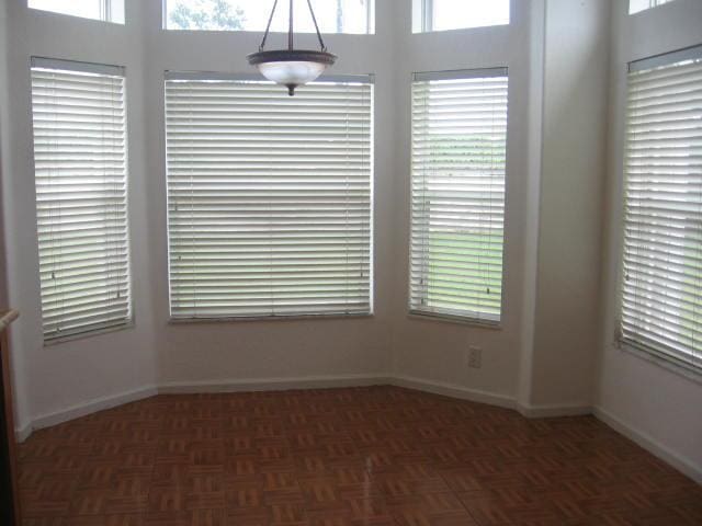 spare room featuring baseboards and a wealth of natural light