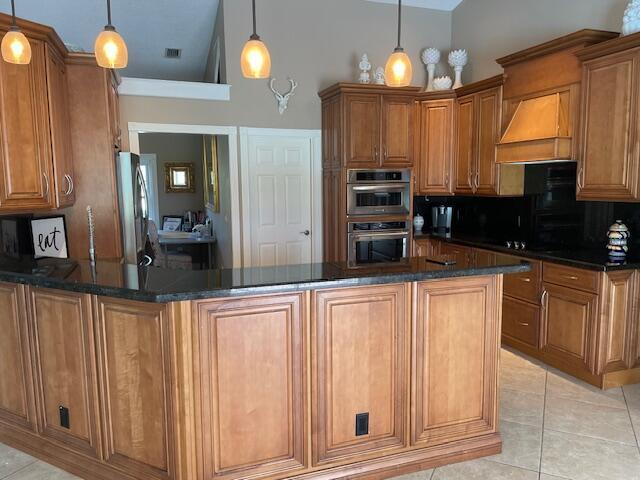 1618 SW Lexington Dr NW, Port Saint Lucie, FL 34953 - kitchen with appliances with stainless steel finishes, brown cabinets, light tile patterned floors, and backsplash