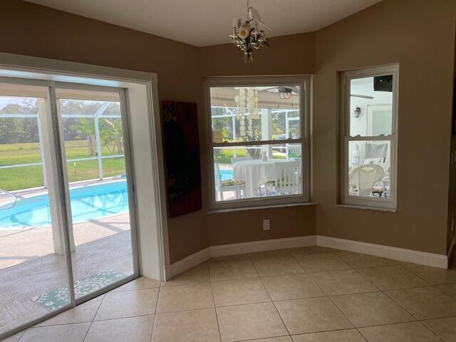 1618 SW Lexington Dr NW, Port Saint Lucie, FL 34953 - unfurnished dining area with healthy amount of natural light, baseboards, and light tile patterned flooring