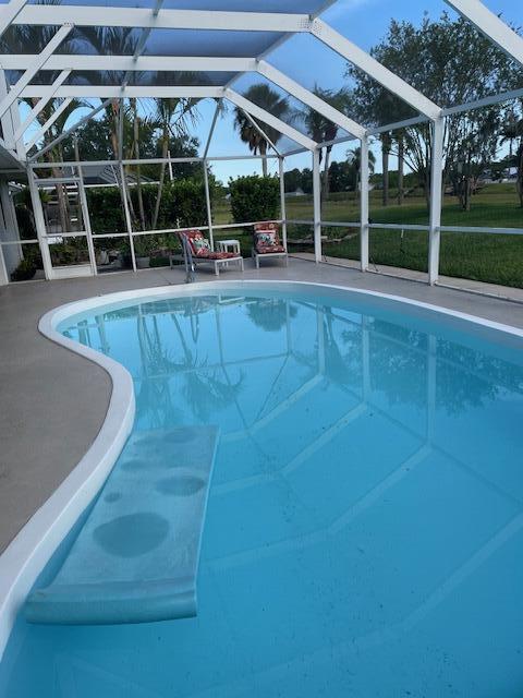 1618 SW Lexington Dr NW, Port Saint Lucie, FL 34953 - swimming pool with glass enclosure and a patio area