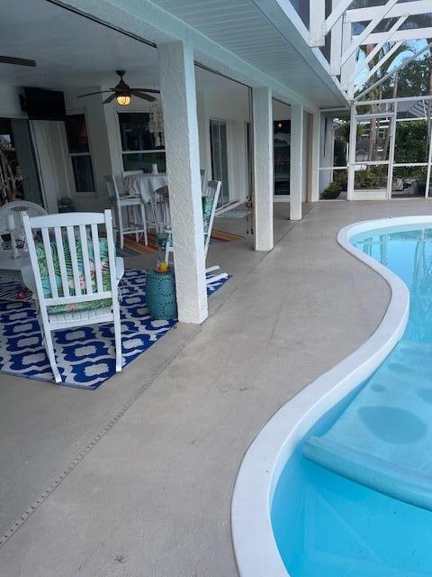 1618 SW Lexington Dr NW, Port Saint Lucie, FL 34953 - outdoor pool with a ceiling fan, a patio, and glass enclosure
