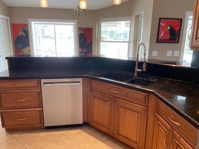 1618 SW Lexington Dr NW, Port Saint Lucie, FL 34953 - kitchen featuring stainless steel dishwasher, a sink, brown cabinets, and light tile patterned flooring
