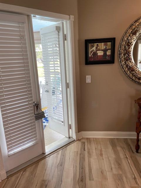 1618 SW Lexington Dr NW, Port Saint Lucie, FL 34953 - doorway with baseboards and wood finished floors