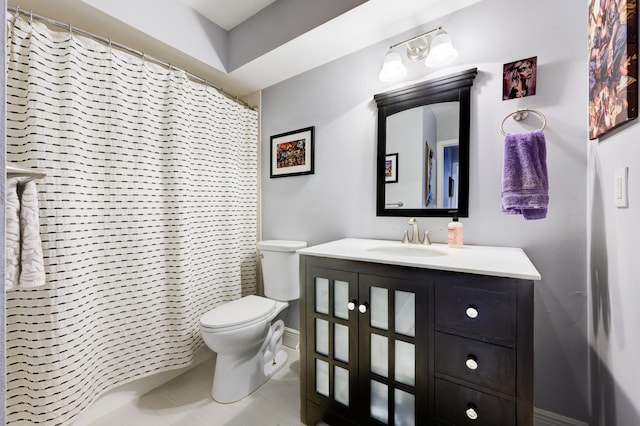 bathroom with toilet, vanity, baseboards, and tile patterned floors