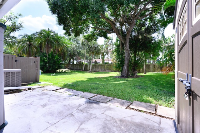 view of yard with central AC unit and a patio area