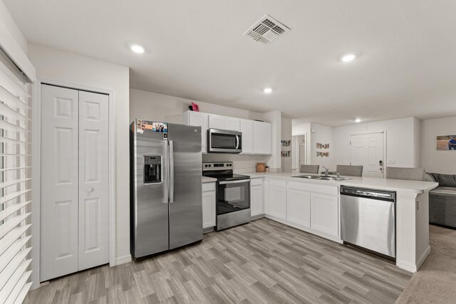 5248 NW Gamma St, Port Saint Lucie, FL 34986 - kitchen featuring appliances with stainless steel finishes, a sink, light wood-type flooring, and recessed lighting