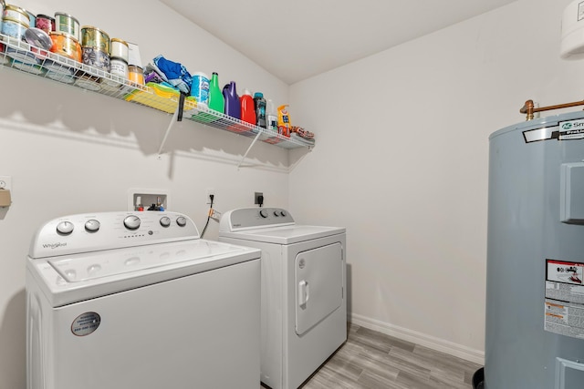 5248 NW Gamma St, Port Saint Lucie, FL 34986 - laundry area featuring water heater, washer and clothes dryer, light wood-type flooring, and baseboards