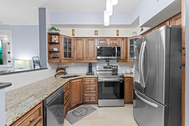 802 W Windward Way Unit 304, Lantana, FL 33462 - kitchen with appliances with stainless steel finishes, brown cabinetry, light stone countertops, and glass insert cabinets