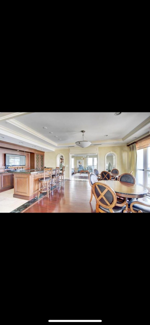 802 W Windward Way Unit 304, Lantana, FL 33462 - dining space with a raised ceiling, crown molding, and light wood-style flooring