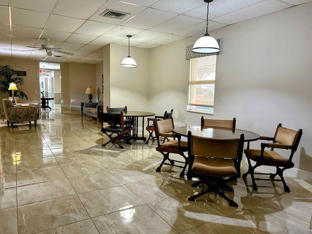 dining room with a drop ceiling, visible vents, baseboards, and a ceiling fan
