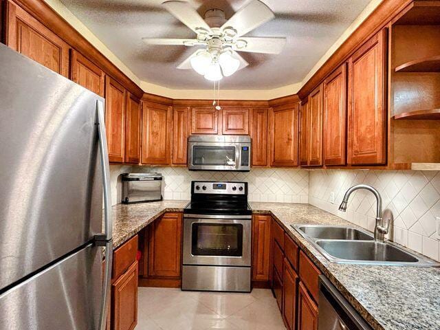 kitchen featuring a sink, brown cabinets, open shelves, and appliances with stainless steel finishes