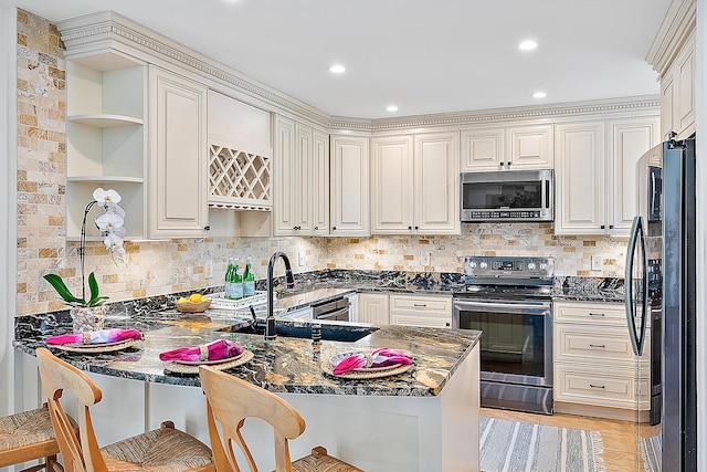2703 Fairway Dr N, Jupiter, FL 33477 - kitchen with appliances with stainless steel finishes, a peninsula, open shelves, dark stone countertops, and a breakfast bar