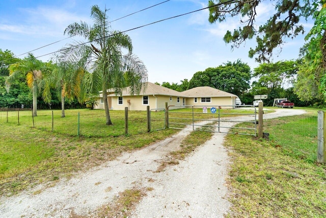 view of front facade featuring driveway, a gate, and stucco siding