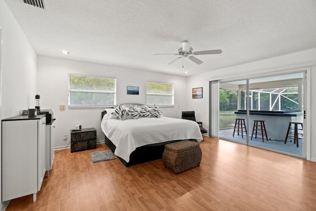 bedroom with access to outside, light wood-style floors, a textured ceiling, ceiling fan, and recessed lighting