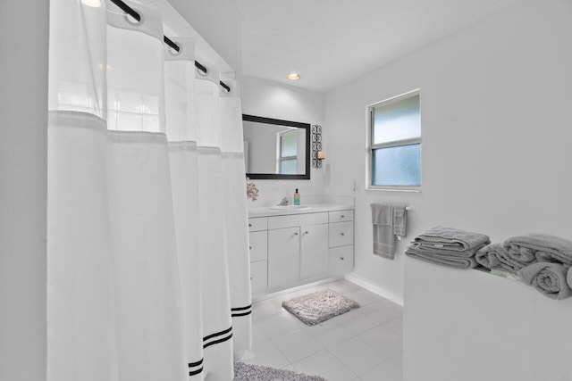 full bath featuring a shower with curtain, tile patterned flooring, vanity, and baseboards