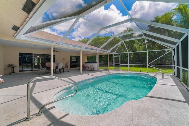 swimming pool featuring a patio, ceiling fan, and glass enclosure