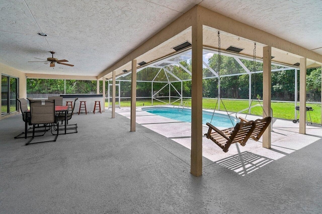 swimming pool featuring a patio area, a lanai, a ceiling fan, and a lawn