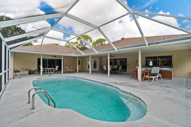 swimming pool featuring a ceiling fan, a patio area, and glass enclosure