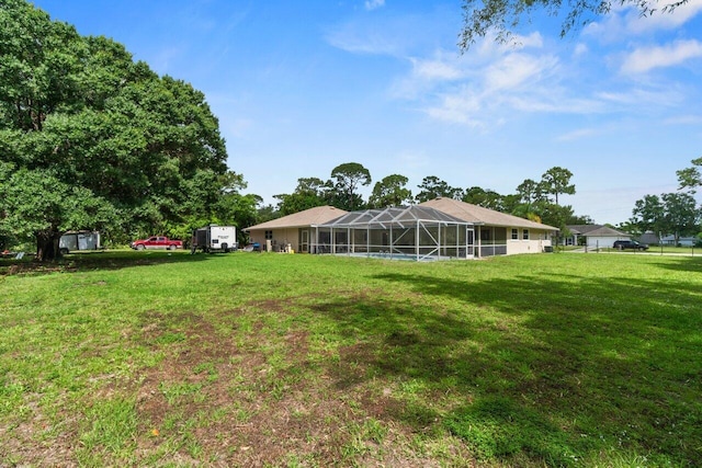 view of grassy yard featuring glass enclosure
