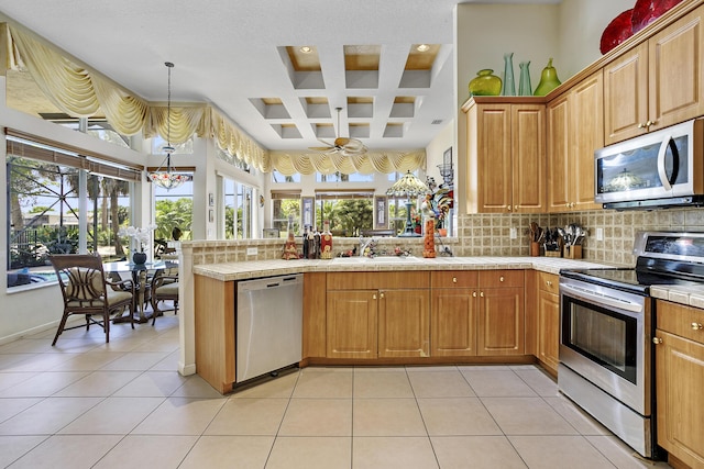 1815 Waldorf Dr, Royal Palm Beach, FL 33411 - kitchen featuring appliances with stainless steel finishes, a peninsula, coffered ceiling, tasteful backsplash, and a sink
