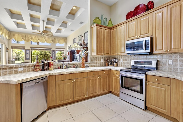 1815 Waldorf Dr, Royal Palm Beach, FL 33411 - kitchen with appliances with stainless steel finishes, a sink, a peninsula, coffered ceiling, and a ceiling fan