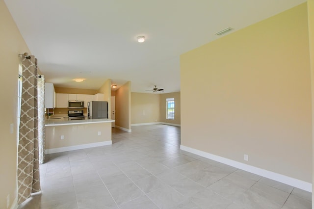 102 SW 13th Ave, Delray Beach, FL 33444 - unfurnished living room with light tile patterned flooring, baseboards, and a ceiling fan