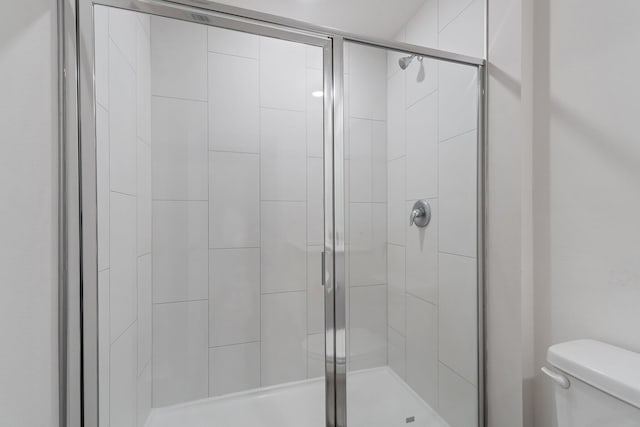 full bath with toilet and a shower stall