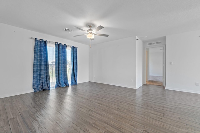 unfurnished room featuring ceiling fan, wood finished floors, baseboards, and a textured ceiling