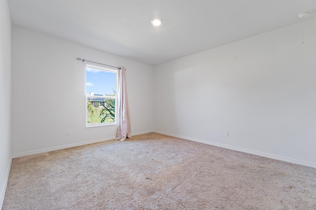 empty room with baseboards and light colored carpet