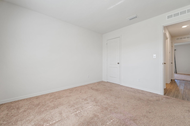 unfurnished room featuring light carpet and baseboards