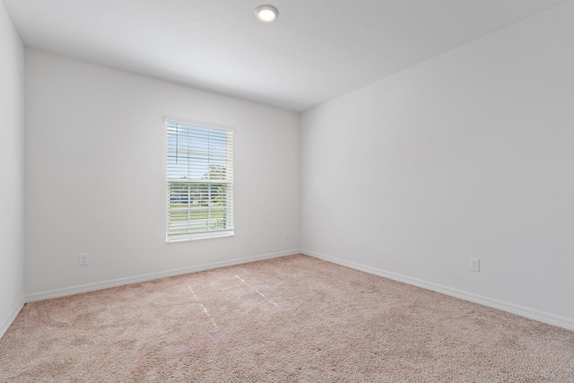 carpeted spare room featuring baseboards