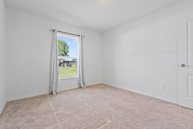 carpeted spare room featuring baseboards