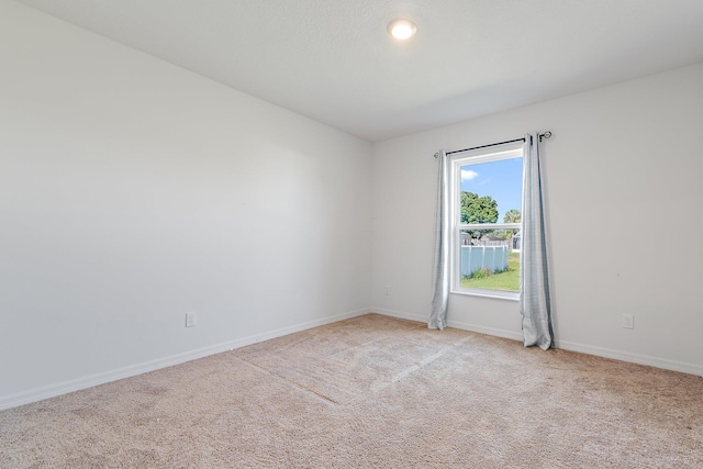 carpeted spare room with baseboards