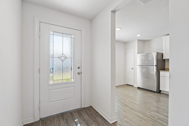 doorway featuring wood finished floors and baseboards