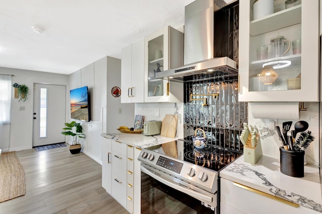 115 W 31st Ct, Riviera Beach, FL 33404 - kitchen with light stone countertops, light wood-type flooring, stainless steel range with electric cooktop, and wall chimney exhaust hood