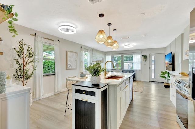 115 W 31st Ct, Riviera Beach, FL 33404 - kitchen with light wood-style floors, plenty of natural light, a kitchen breakfast bar, and a sink