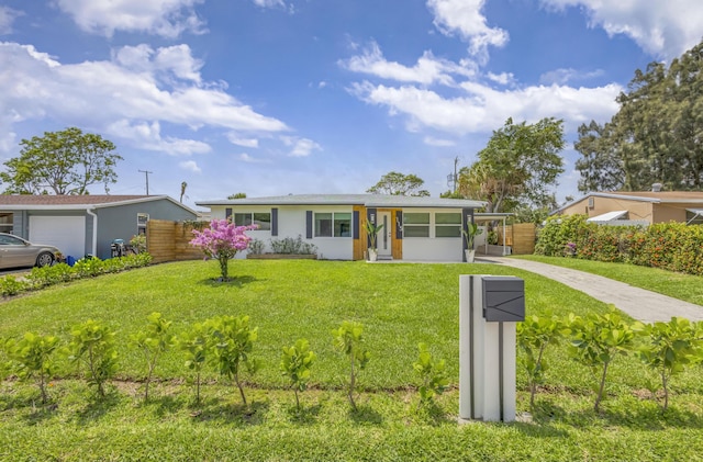 115 W 31st Ct, Riviera Beach, FL 33404 - single story home with a sunroom, stucco siding, fence, and a front yard